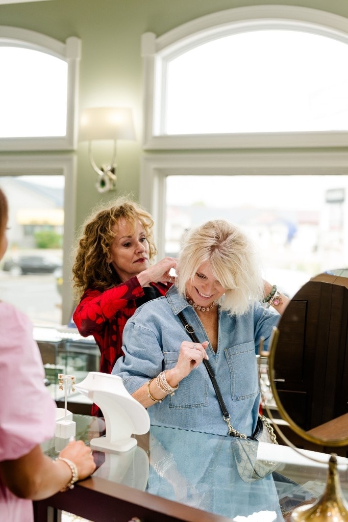 A Giganti & Giganti sales associate helps a client fit a pair of diamond earrings at the showroom counter