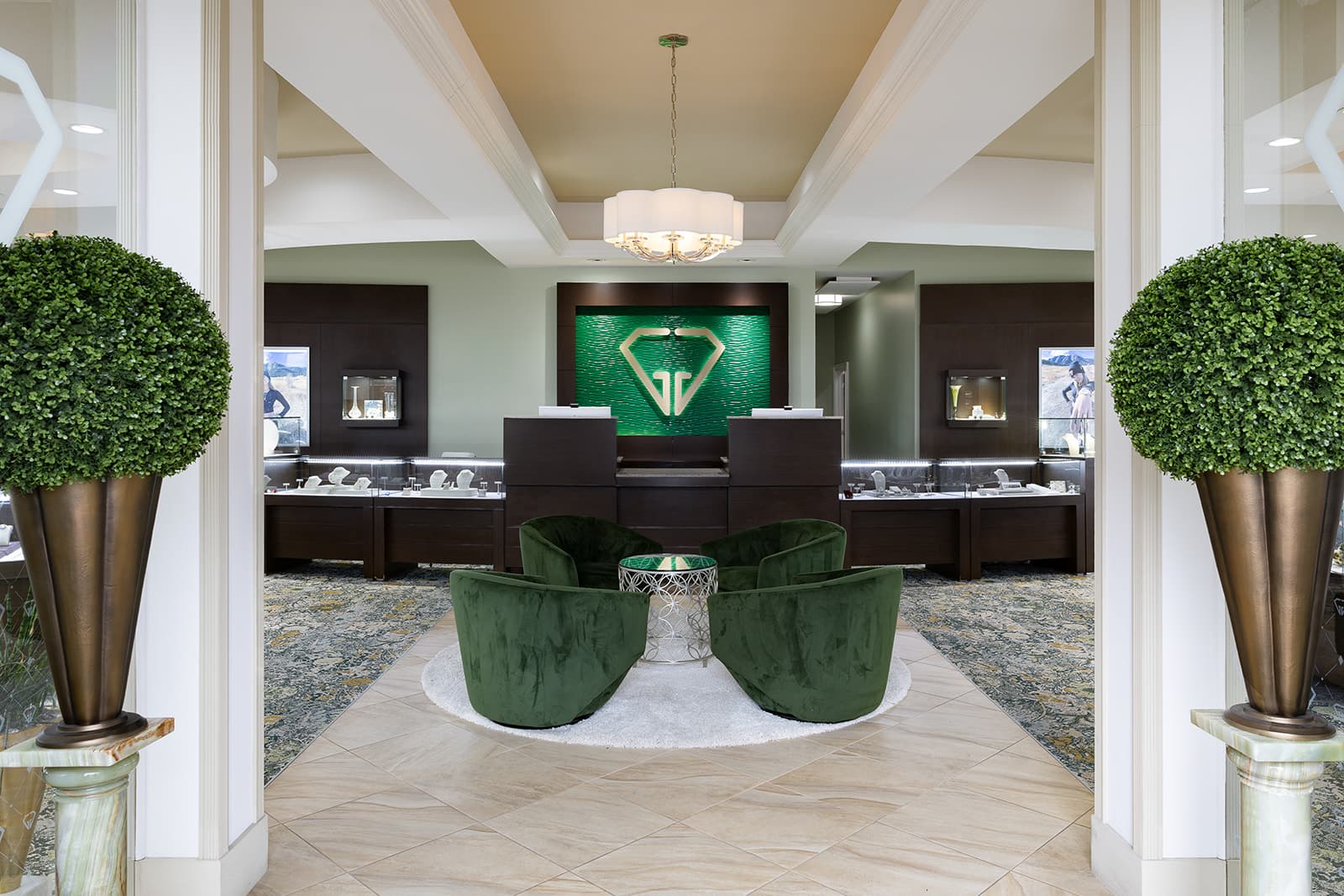 Inside the Giganti & Giganti showroom — symmetrical entryway with green velvet chairs and the GG diamond mark on the back wall