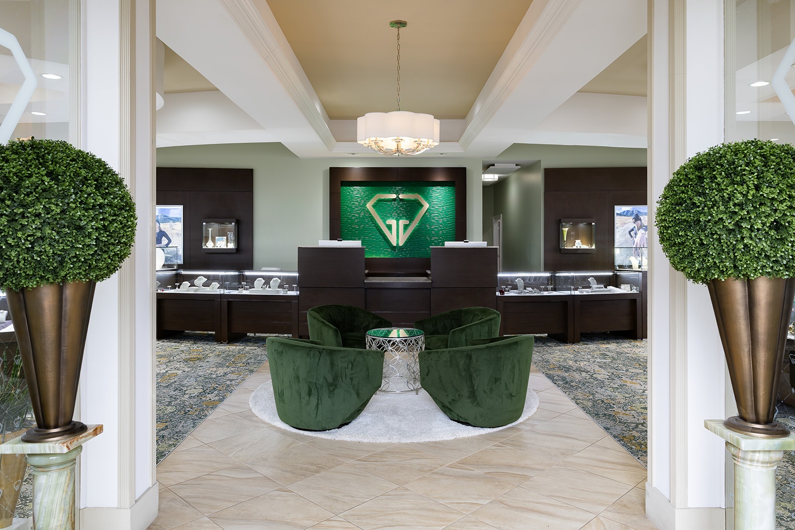 Inside the Giganti & Giganti showroom: symmetrical entryway with green velvet chairs and the GG diamond mark on the back wall