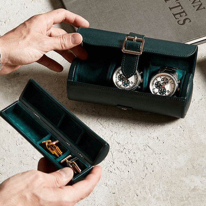 Deep green watch roll holding two watches with a matching accessory case